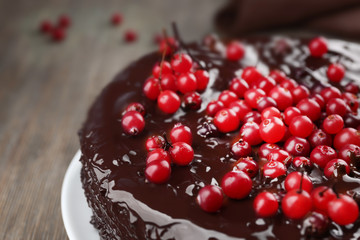 Chocolate cake with cranberries on wooden table, closeup