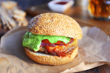 Big tasty hamburger on a paper, close up