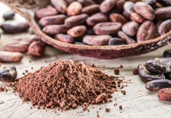 Cocao powder and cocao beans on the wooden table.