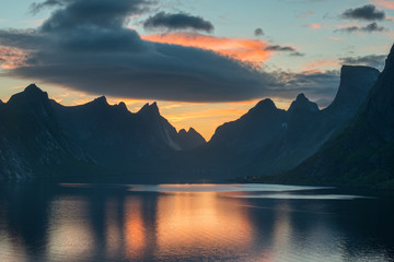 Beautiful sunset near the great mountains and clear silence water at Reine, Lofotens. Amazing nature of Norway. Cloudscape - obrazy, fototapety, plakaty