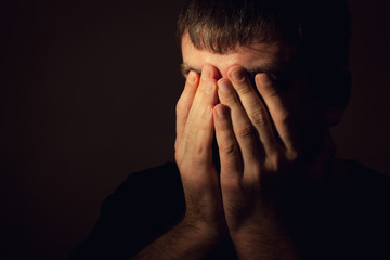 Man in depression, hands covered his face