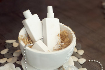 Set of white bottles of cream. The white tubes in a porcelain basket. 