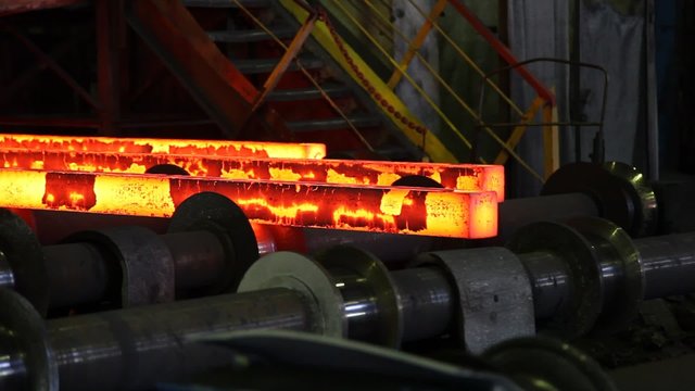 Hot steel ingots on conveyor