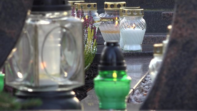 candles between grave old stone tomb. Static blurred shot. 4K
