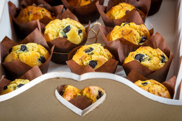 Great quantity of sweet biscuits muffins on a tray with heart.