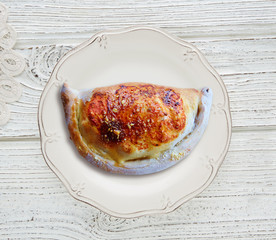 Pizza Calzone folded as a patty on a wooden
