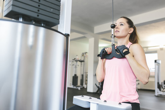 Woman doing cable pulldowns in gym