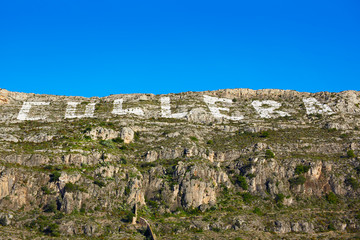 Fototapeta na wymiar Cullera mountain with white sign writed on in