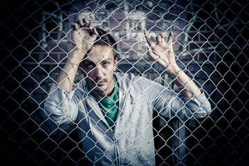 a young man behind bars close