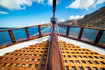 On board view from a traditional ship cruising on Aegean sea next to Santorini island.