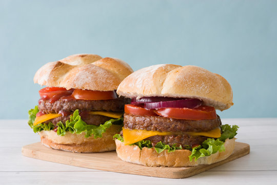 Delicious burgers with cheddar cheese, tomato, lettuce and onion
