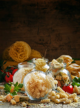 Dry Italian pasta spiraline in glass jars, selective focus