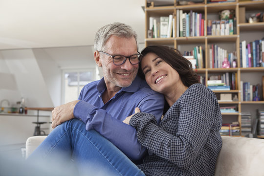Smiling mature couple cuddling at home