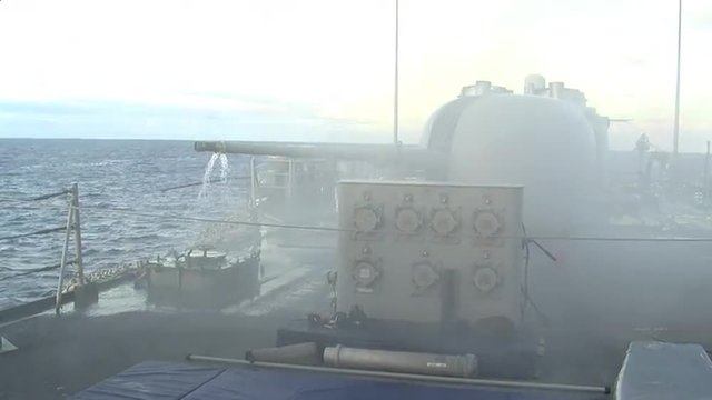 A U.S. Navy warship fires its guns.