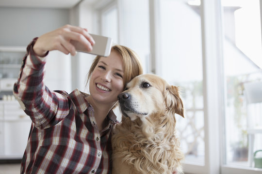 Portrait of smiling young woman taking a selfie with her dog