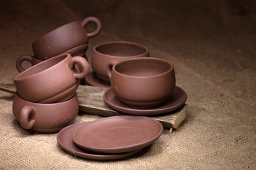 Clay cups and saucers on a sacking about old boards