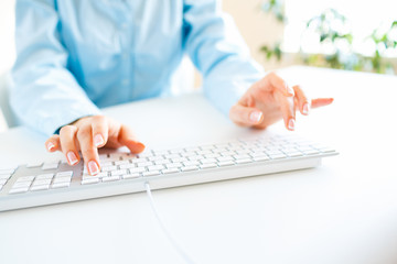 Woman office worker typing on the keyboard