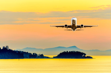 Fototapeta na wymiar Sunset or sunrise (dawn, dusk ) flight of the airplane (jet) over beautiful sky and ocean.