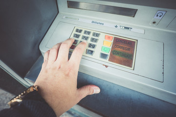 Close-up of man's hand pushing button on atm machine