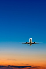 Obraz premium Zachód lub wschód słońca (świt, zmierzch) lot samolotu (odrzutowca) nad pięknym niebem i oceanem.