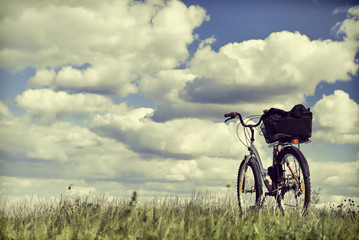 Bike on a grass against clouds. To a photo color toning is applied