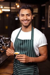 Smiling waiter drinking a coffee at the coffee shop