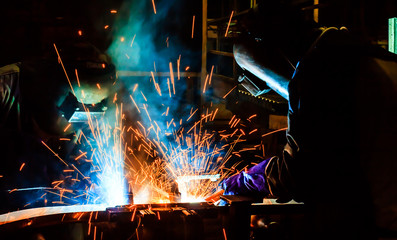 worker with protective mask welding metal