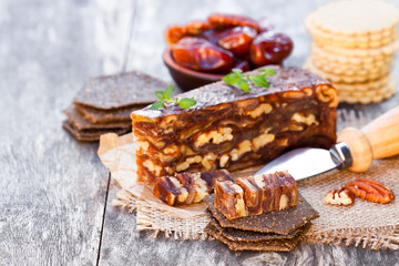 Date  walnut wedge with multigrain crackers on wooden table
