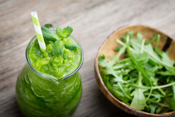 Rucola smoothie, on the grey  background.