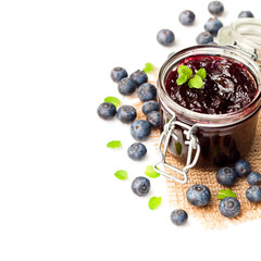 homemade  blueberry jam in a jar and fresh blueberries isolated