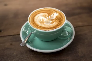 Foto op Plexiglas hot cappuccino with latte art on wood background © tonefotografia