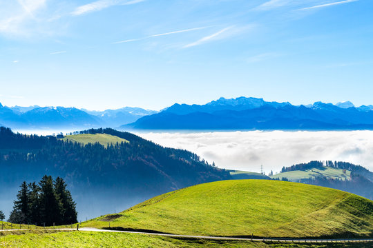 Panoramic cloudscape skyline view of Swiss Alps in blue sky.