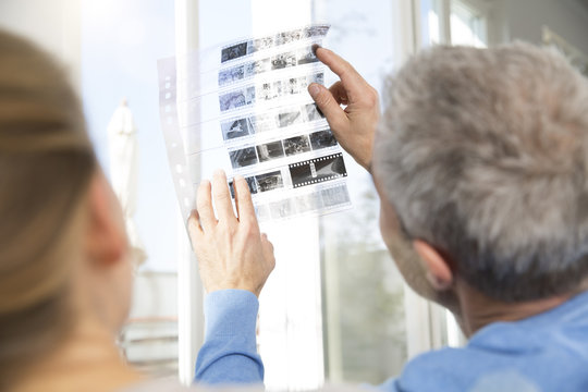 Couple at home looking at old photographs