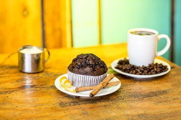 Chocolate Muffins with cup of coffee served with coffee beans ar