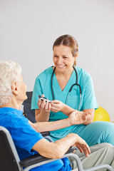 Blutdruckmessung bei Seniorin mit Diabetes