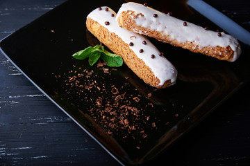 two exquisite cream dessert eclair with fresh mint leaves