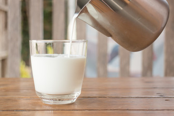 Pour milk from a pitcher into a glass
