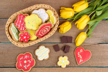 Homemade baked gingerbread and tulips on wooden table