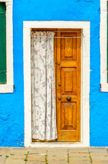 Entrance of a colorful apartment building in Burano, Venice, Italy.