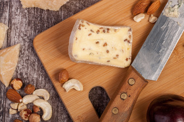 Different type of cheese and nuts on vintage wooden background