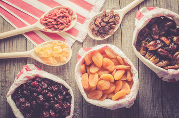 Overhead shot of dried fruits in paper bag on wooden table
