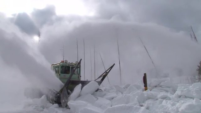Snowplows clear roads in Yellowstone National park.