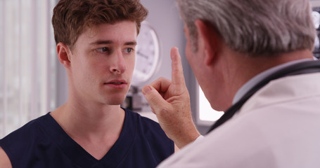Portrait of young caucasian sports athlete having eyesight check © Mark Adams