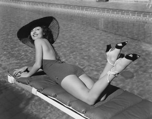 Woman sunbathing at pool 