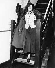 Young woman waving on a staircase and smiling 