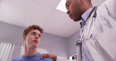 Obraz premium Young adult male patient talking with medical physician