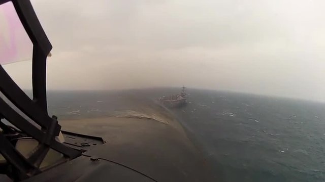 POV shot from jet fighter plane landing on an aircraft carrier.