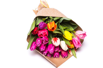 Bouquet of spring multicolor tulips flowers wrapped in present paper  isolated on white background