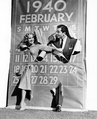 Couple bursting through leap year calendar  - obrazy, fototapety, plakaty