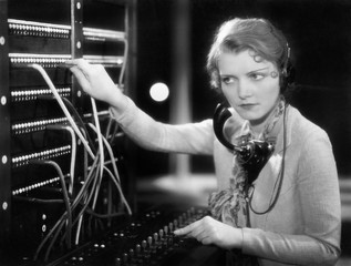 Young woman working as a telephone operator  - obrazy, fototapety, plakaty